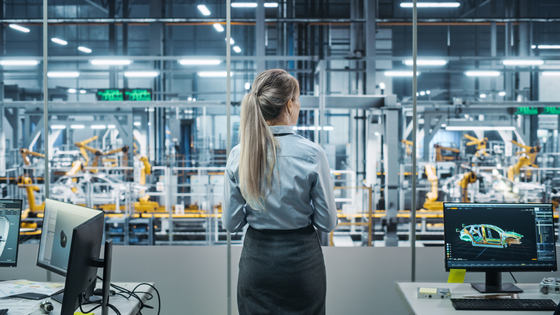 Professional woman assessing EV manufacturing plant with tech