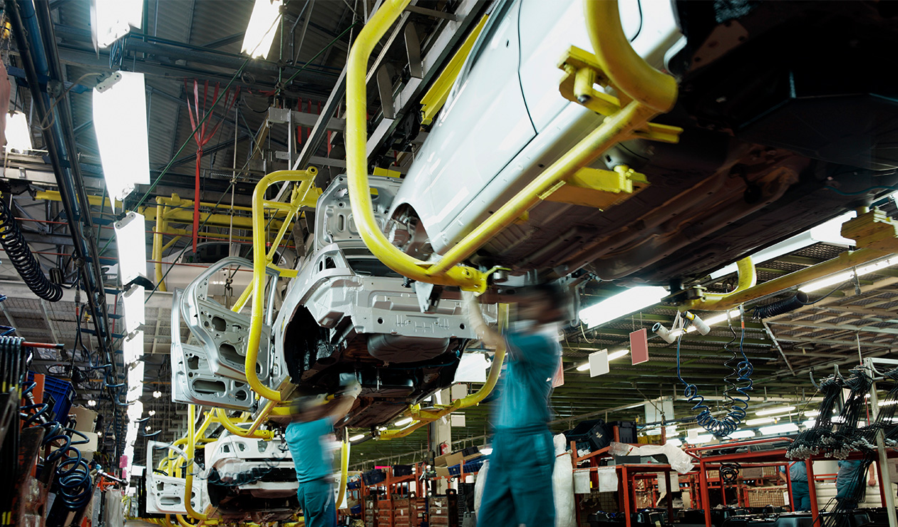 dos hombres trabajando en la línea de producción de automóviles